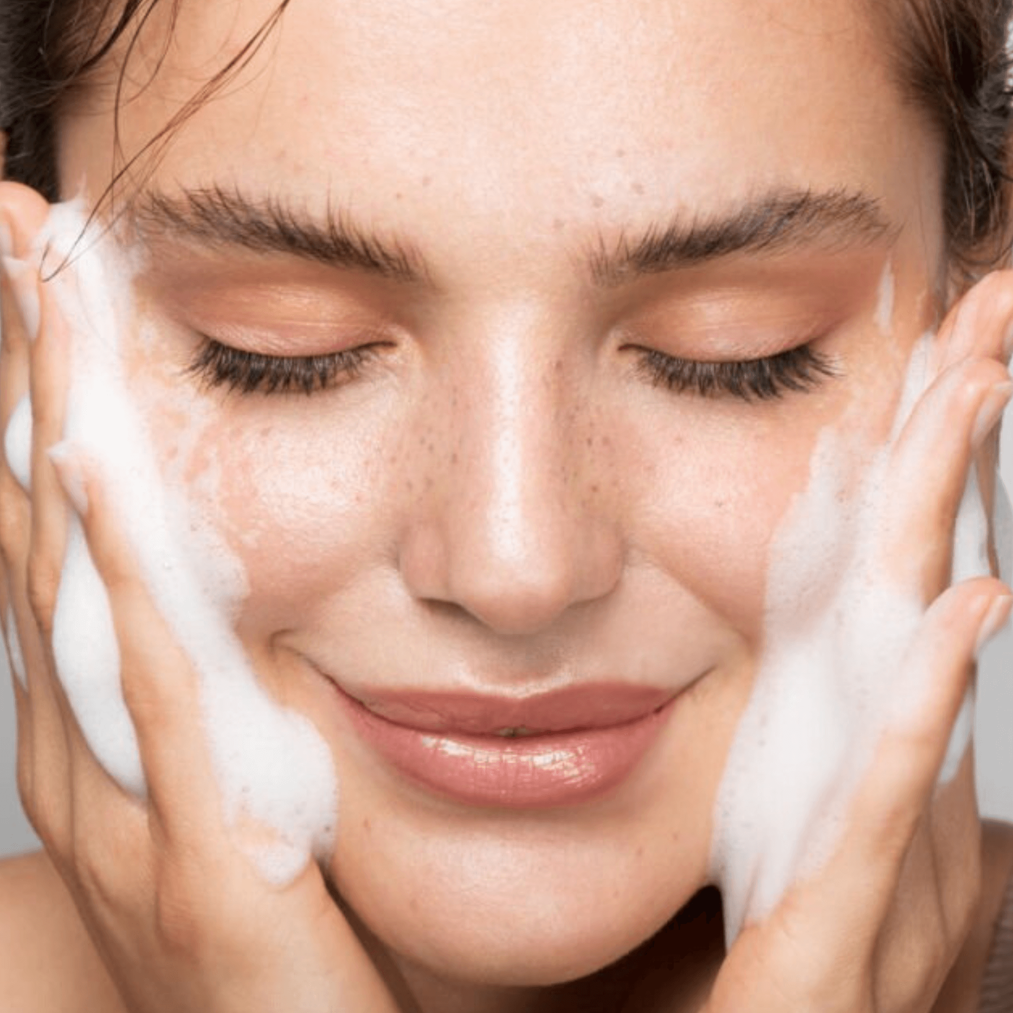 Preparing the skin: "Woman cleansing her face before applying a serum or moisturizer to optimize the effects of the LED facial massage.